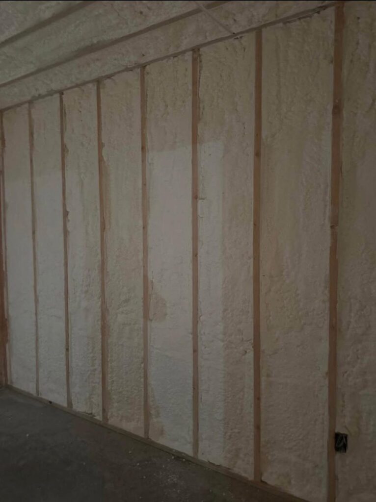 Closed-cell spray foam filling every stud bay of a basement wall