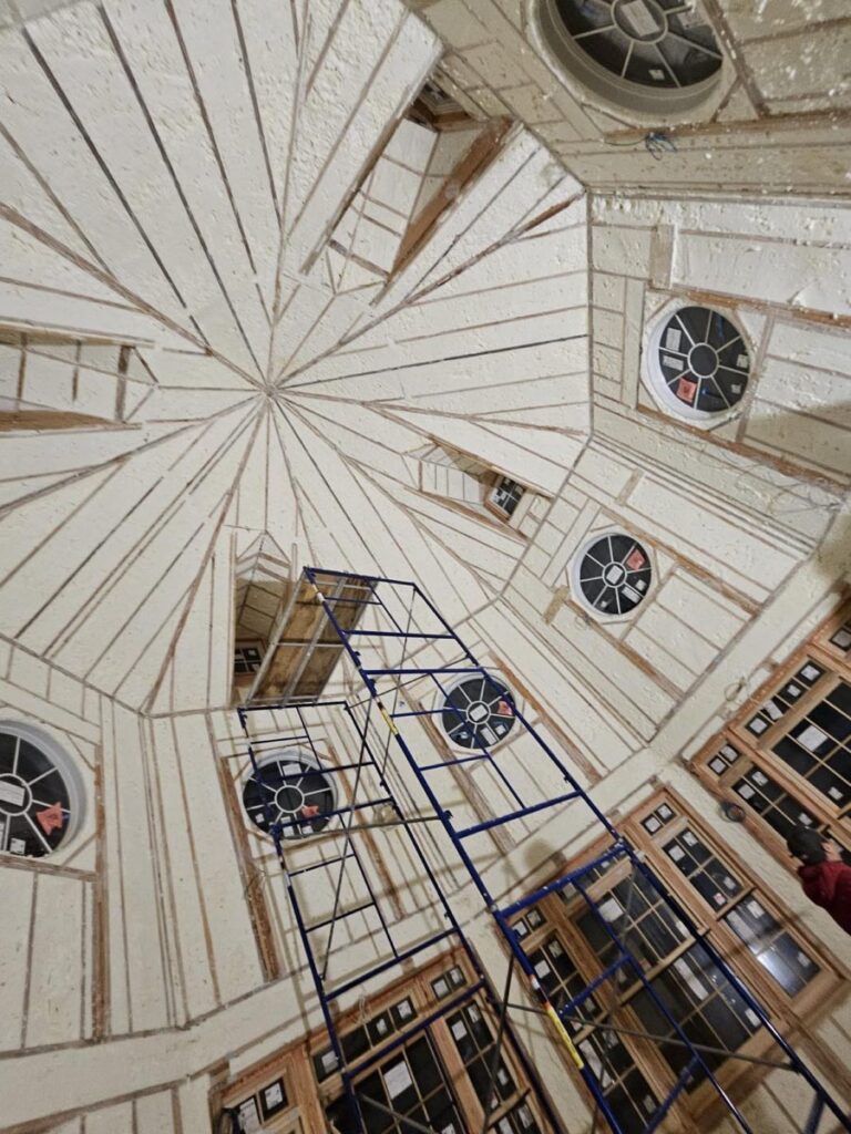 Spray foam applied to a vaulted rotunda ceiling from scaffolding