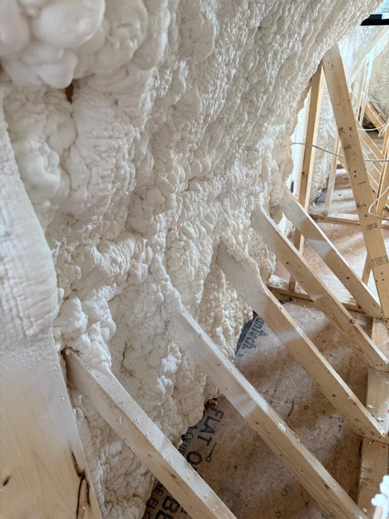 Close-up of open-cell spray foam applied to an attic roof deck