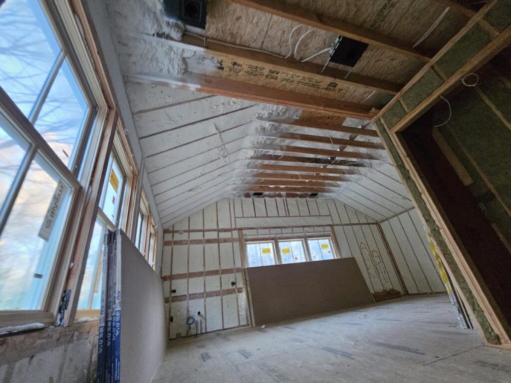 Spray foam on the rafters and gable walls of a converted attic room