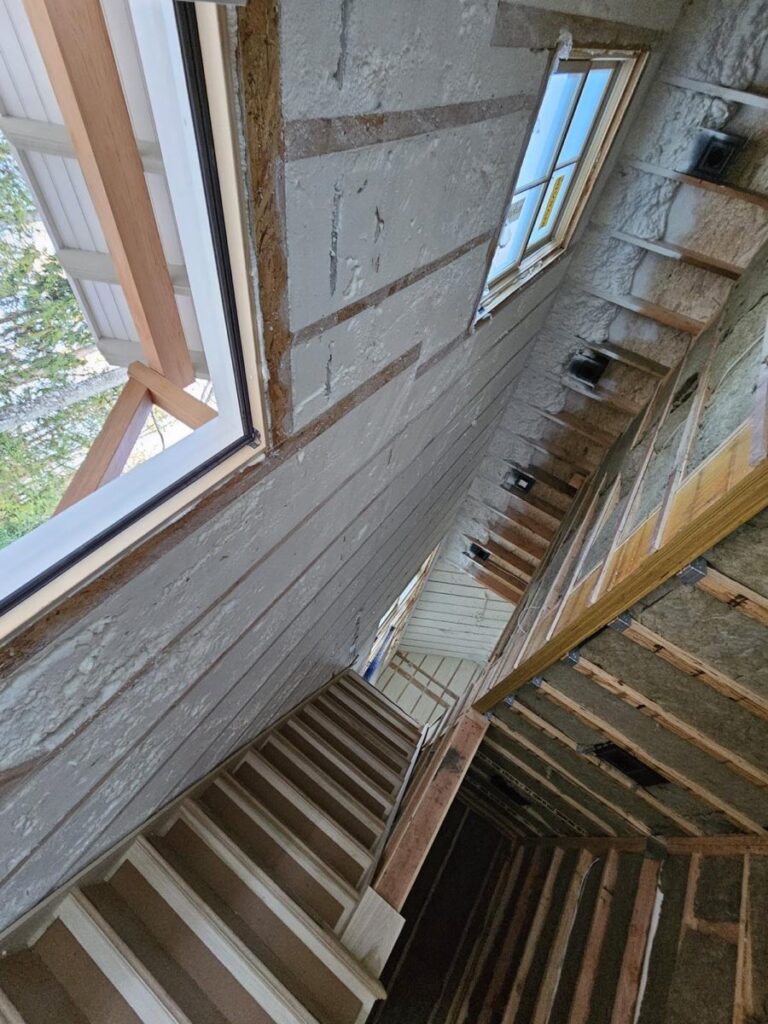 Foam-insulated stairwell walls and roofline in a house under construction